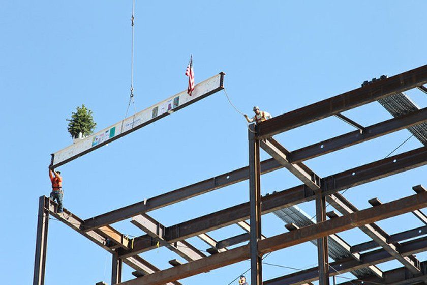 Construction workers at the new medical center place the last steel beam on the structure in a "topping out" ceremony