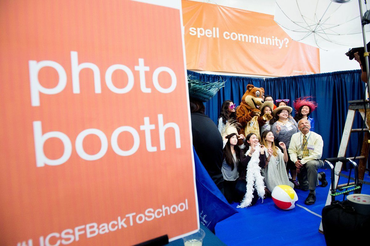 UCSF School of Pharmacy Dean B. Joseph Guglielmo, PharmD, at photo booth area poses for a photo with students during the Chancellor's Reception 
