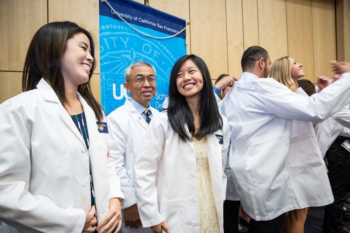 New UCSF School of Dentistry students smiling their white coats