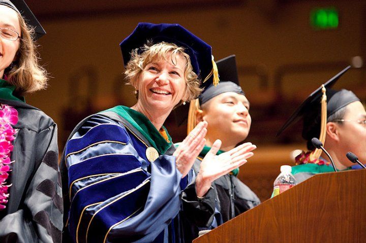 chancellor applauding at commencement podium