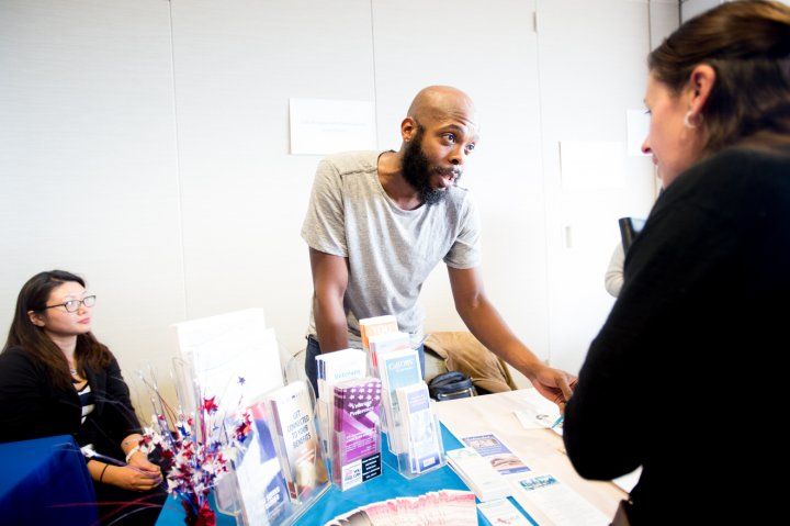 A UCSF employee hands out information and brochures at a Veterans Job Fair and Open House