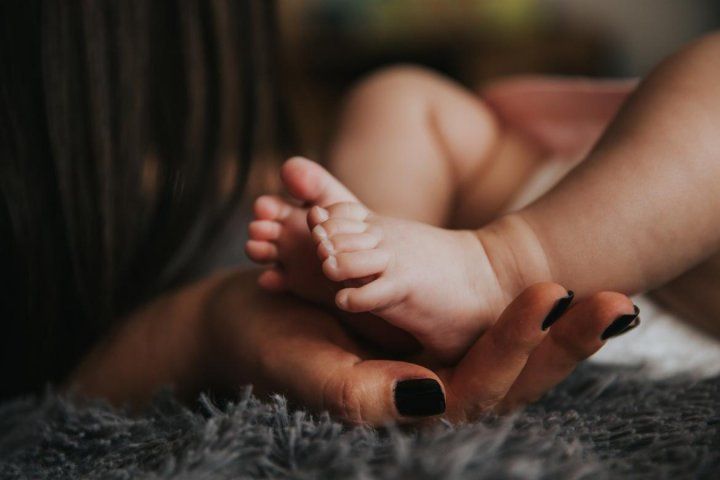 Mom's hand holding baby's feet