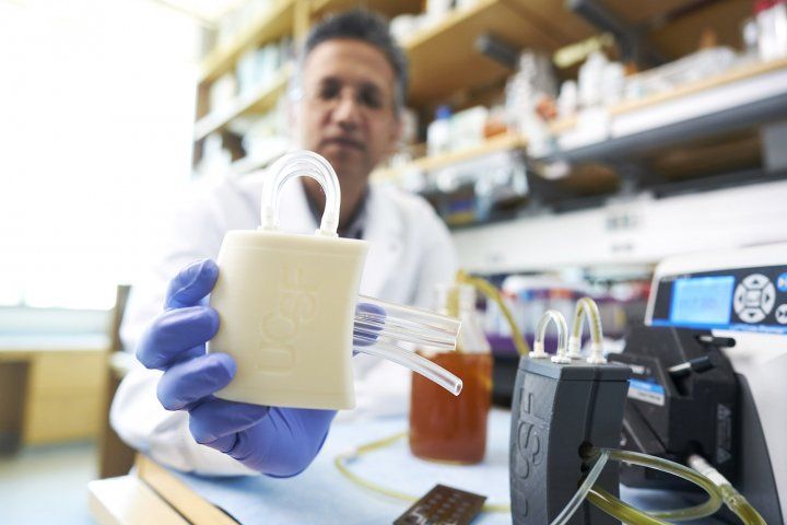 Shuvo Roy holds a prototype of the artificial kidney