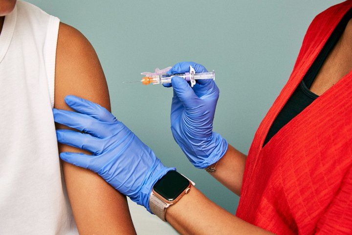 Doctor preparing to administer vaccine shot. 