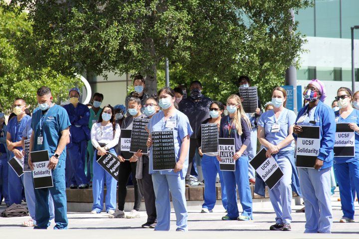 group holds signs during rally outside UCSF Mission Bay Medical Center