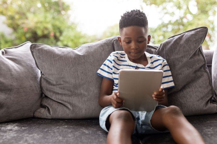 Boy sitting on couch using a tablet