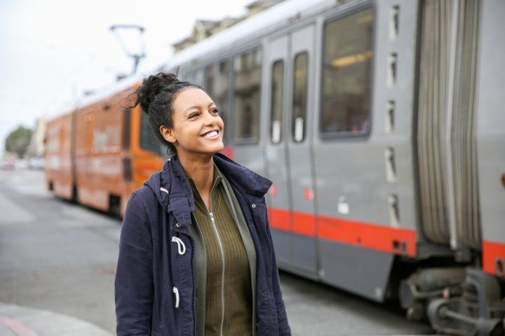A student smiles as the N Judah line comes to Irving Street