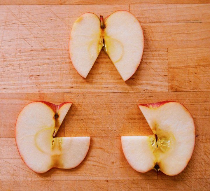 Three apple slices with pieces missing, suggesting a triangle