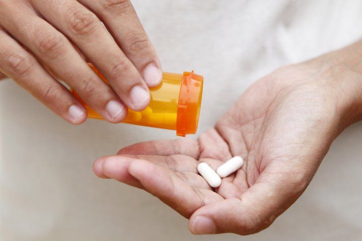 two pills pour from bottle into hand
