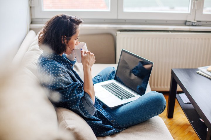 woman sitting on a couch using a laptop
