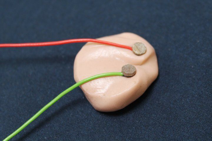 two electrode wires attached to an ear bud