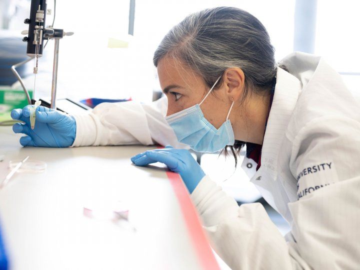 Mariana Casalia in lab coat holding an eppendorf tube