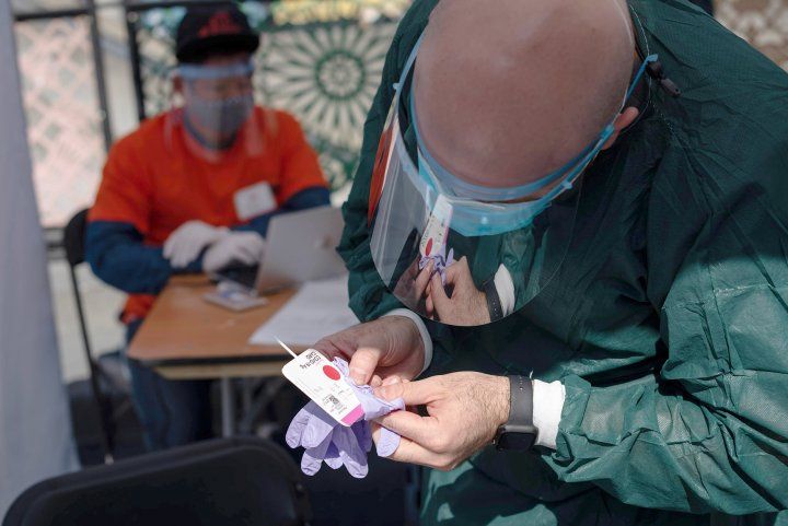 person holds a rapid COVID test