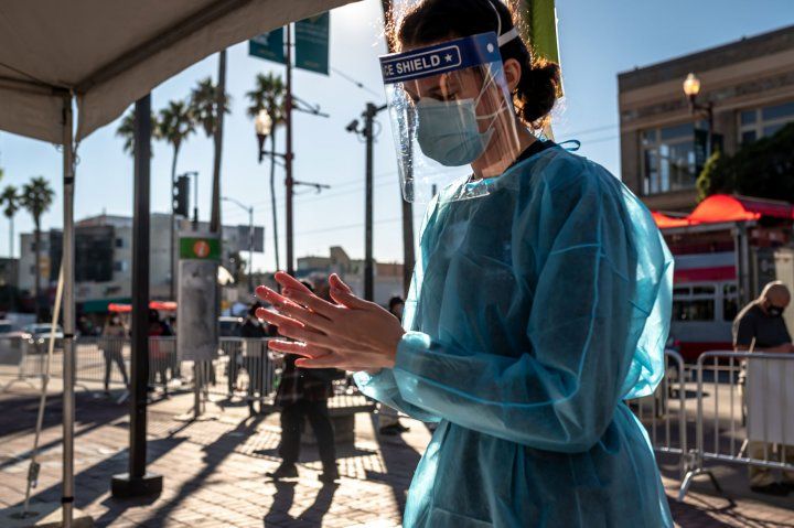 Technician in PPE sanitizing her hands