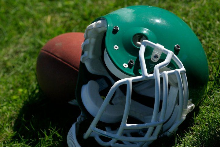 Green football helmet and football on grass