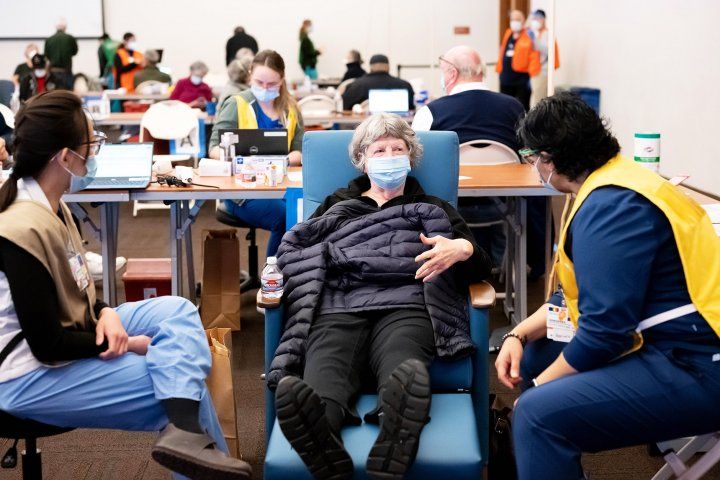 Woman sits in the vaccination clinic in the Rutter Center of the UCSF