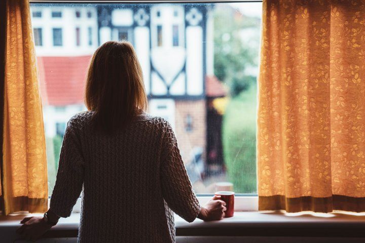 silhouette of a woman standing at a window