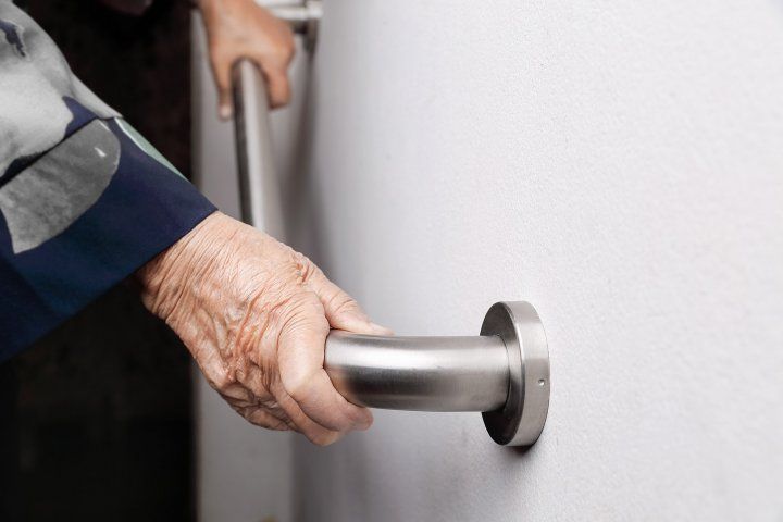 closeup of elderly hands holding a safety bar