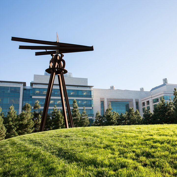 The sculpture points like a compass over a grassy expanse