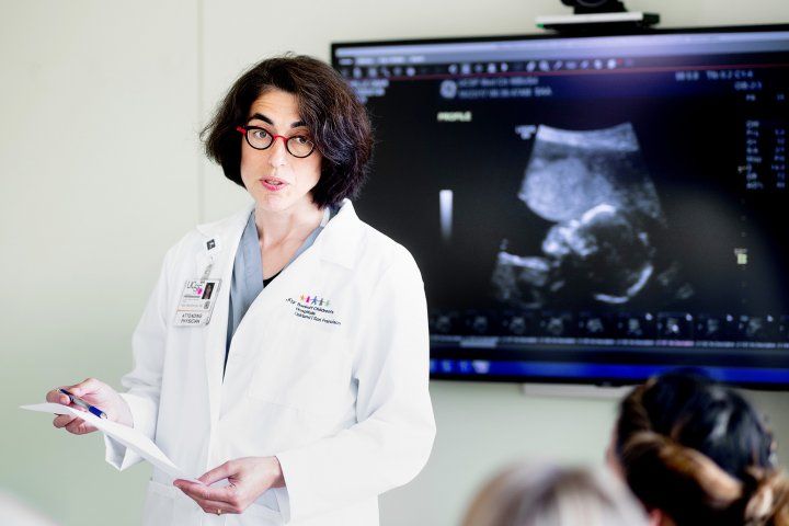 Tippi MacKenzie talks while an ultrasound image of a fetus is on a screen behind her