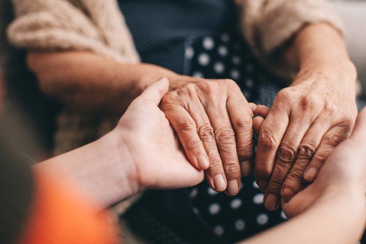 elderly women hold hands