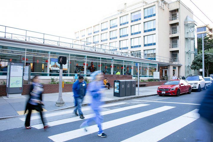 people walk across a crosswalk at UCSF Parnassus Heights campus