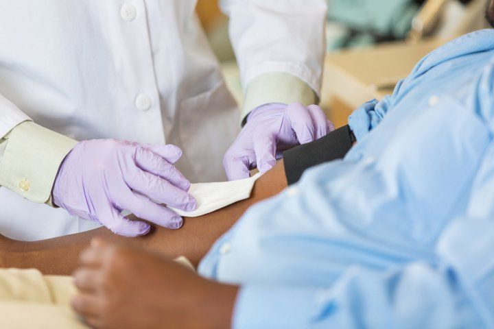 nurse prepares man for a blood draw