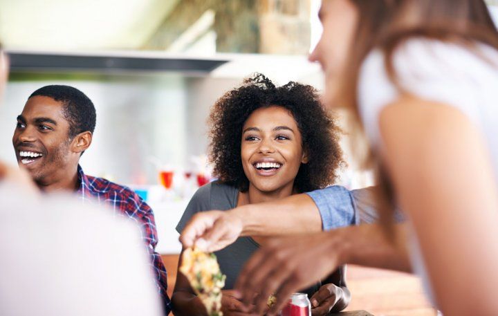 woman laughs with other two young people