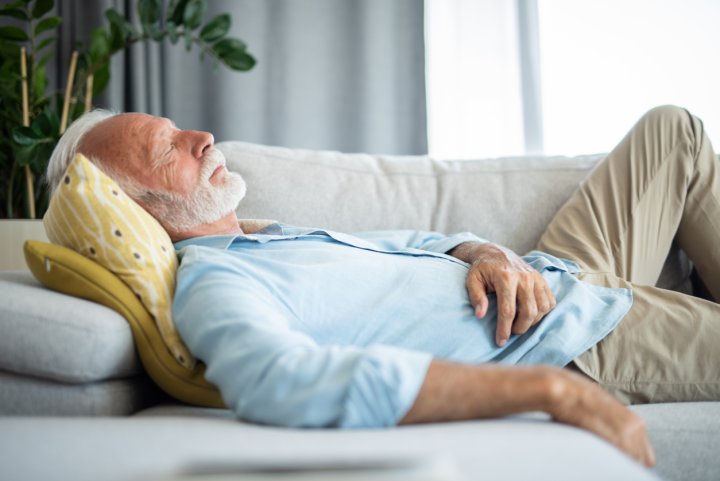 Elderly man taking a nap on a couch