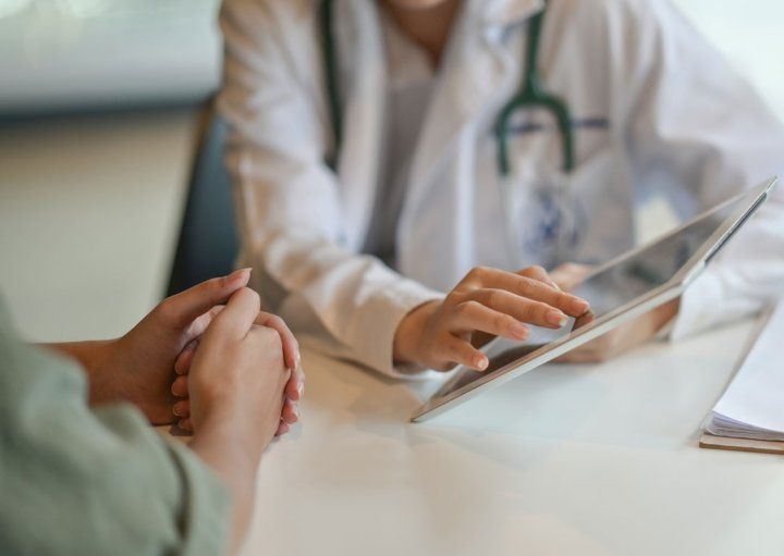 A Ddoctor showing a patient information on a digital tablet