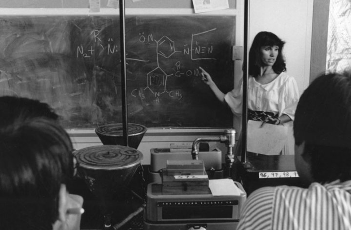 A black and white photo of Kathy Giacomini teaching a class at the UCSF School of Pharmacy in 1985.