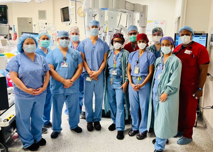Doctors Tom C. Nguyen and Tobias Deuse with their surgical team pose for a photo