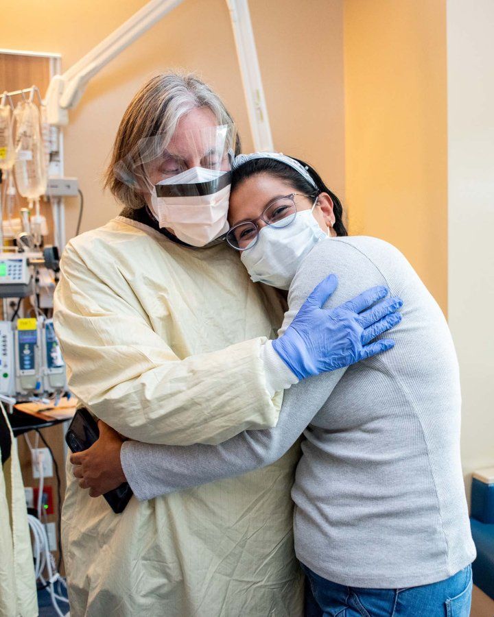 Jennifer hugs the mom, Gina Pareja Ponce de Leon, of her young Artemis-SCID patient who smiles into the camera