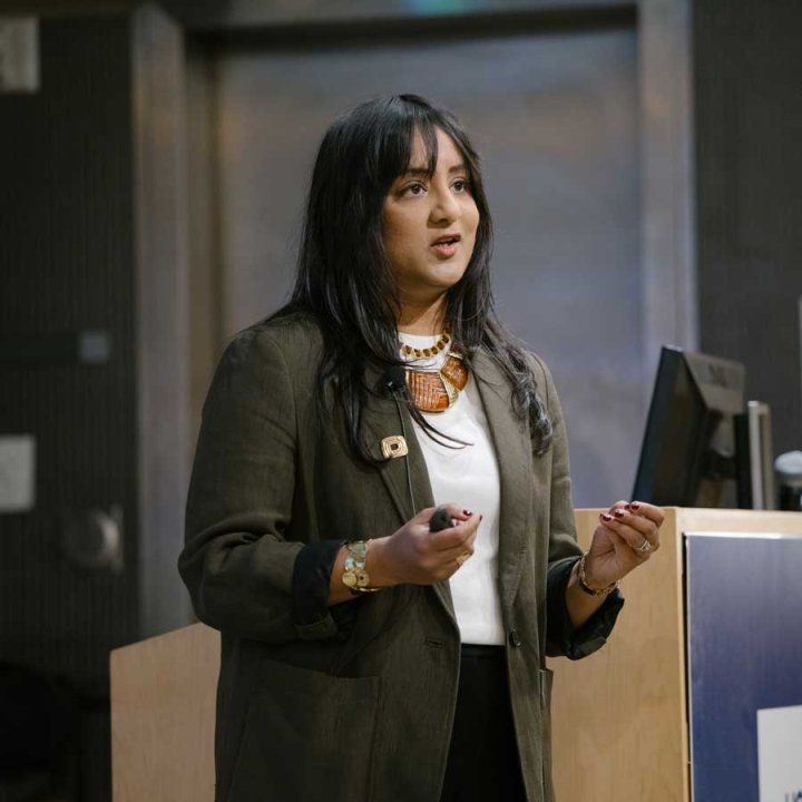 Rushika Perera stands onstage as she delivers a speech.