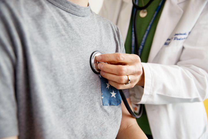 doctor listening to patient's chest with stethoscope