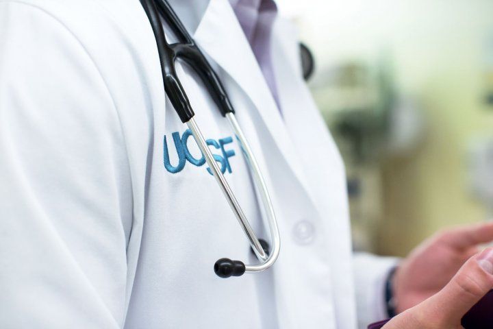 closeup of a person wearing a UCSF white coat with stethoscope