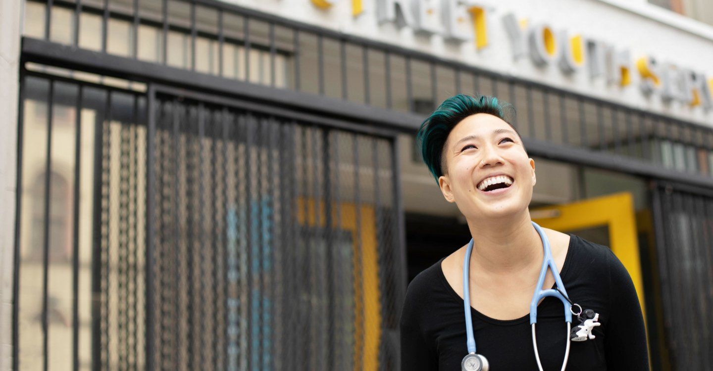 nurse with stethoscope standing in front of Larkin Street Youth Services