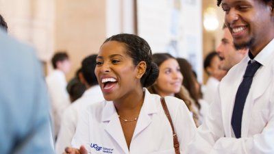 UCSF School of Medicine student smiles in her white coat