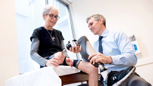 a doctor adjusts a prosthetic leg for a patient