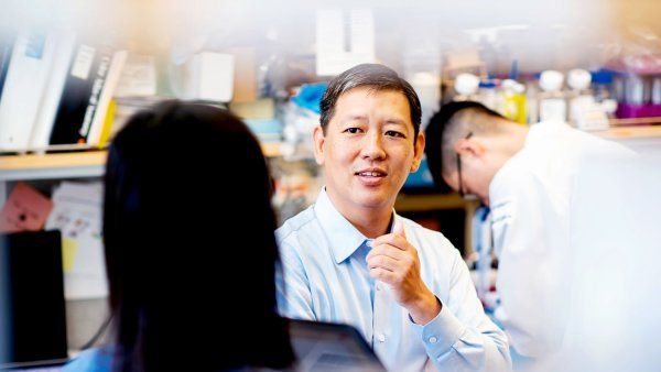 Felix Feng talks to a colleague in his lab