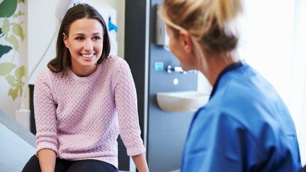 smiling woman talking to doctor