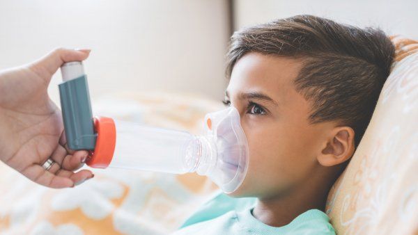 child using an asthma inhaler
