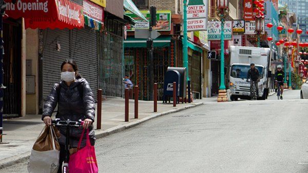 A resident wearing a face mask in Chinatown, San Francisco, is transporting groceries on a bike during the shelter-at-home Covid-19 crisis.