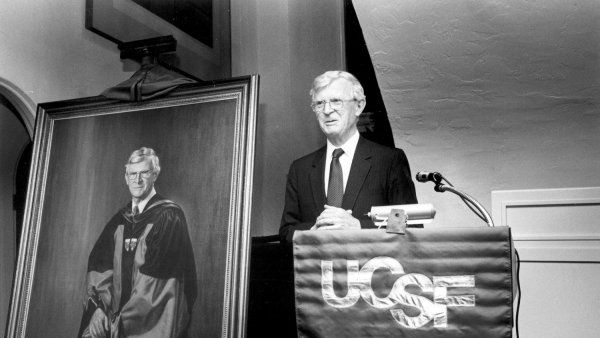 Philip Lee standing at UCSF podium next to his portrait