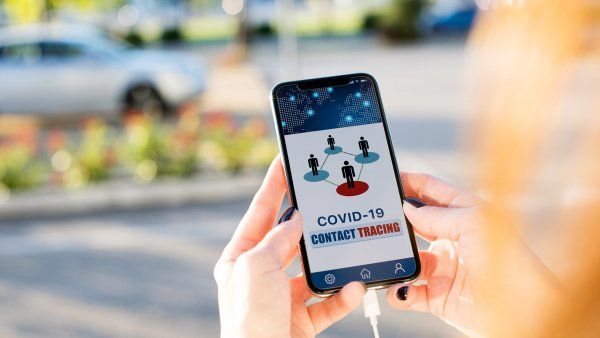 photo illustration shows a COVID-19 contact tracing app on a cellphone