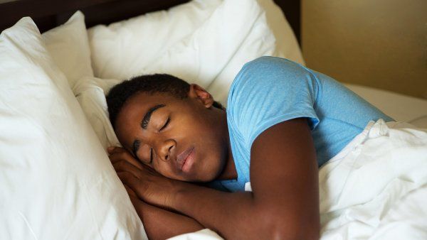 teenage boy sleeping in bed