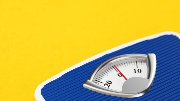 Blue bathroom scale on yellow background