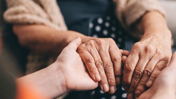 elderly women hold hands