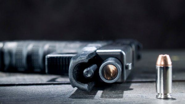 Handgun and bullet on table