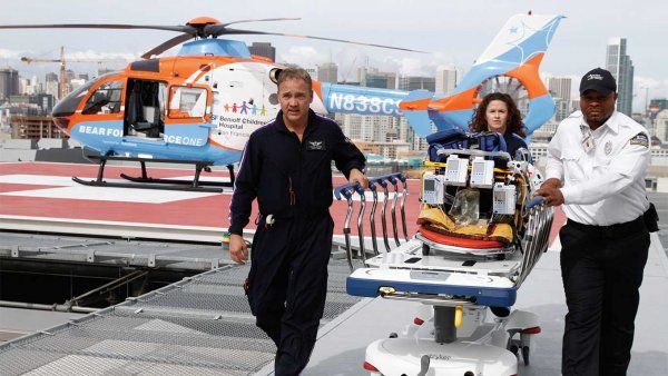 Trained paramedics pushing a gurney arrive from a helicopter at the new hospital.